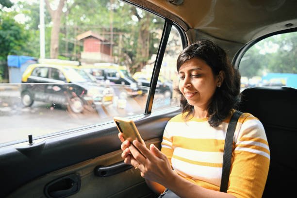 Woman using Smart phone while travelling in cab in Mumbai city
